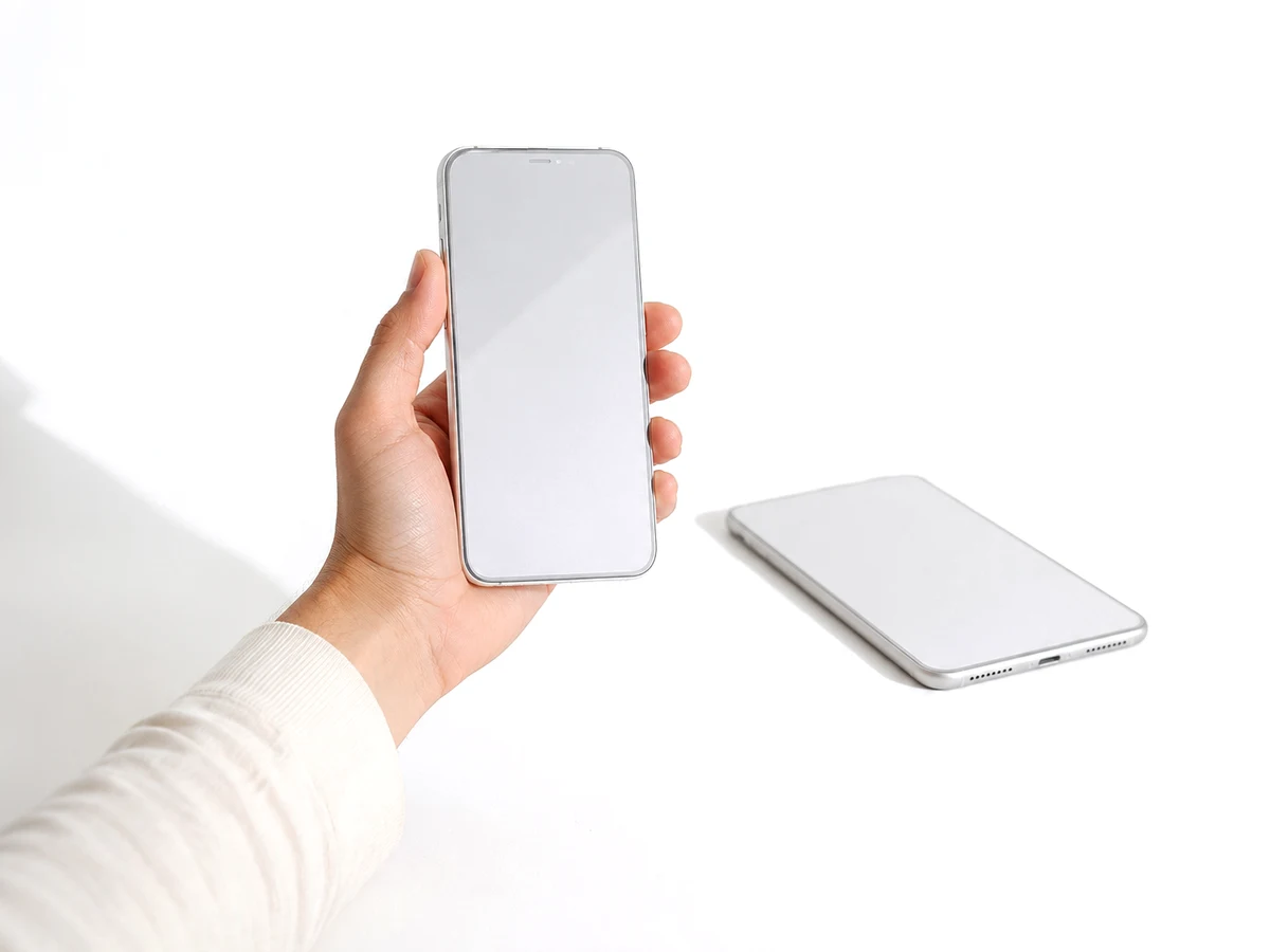 Mão segurando um smartphone para fotografar outro aparelho apoiado na mesa, durante a vistoria